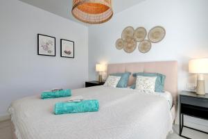 una camera da letto con un grande letto bianco con cuscini blu di Estepona Place - Spacious family city apartment a Estepona