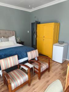 ロードポートにあるBird Songのベッドルーム1室(ベッド1台、椅子1脚、黄色のキャビネット付)
