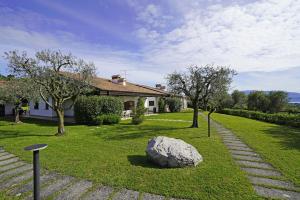 a house with a garden with a rock in the grass at Casa Felicita by Wonderful Italy in Soiano del Lago