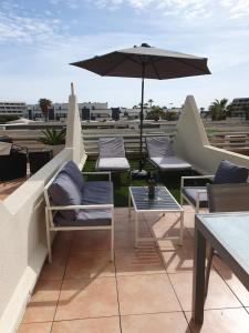 un patio avec des chaises et un parasol sur le toit dans l'établissement The naturist glamour suite, au Cap d'Agde