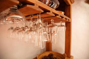 a bunch of wine glasses hanging on a wall at Casa Ajelazul in Galaroza
