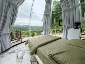 1 dormitorio con cama y ventana grande en ZEN Relaxing Village 