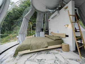 uma cama num quarto com uma grande janela em ZEN Relaxing Village 