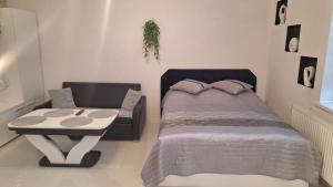 a bedroom with a bed and a chair at Apartament Domi in Gniezno