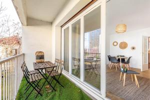 een kamer met een balkon met een tafel en stoelen bij GuestReady - Charming living near Paris in Aubervilliers
