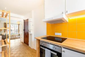 een keuken met een fornuis en een gele muur bij GuestReady - Charming living near Paris in Aubervilliers