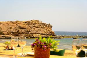 a group of wine glasses sitting on a beach at Maxcaly Playa by Blossom Hotels in Águilas