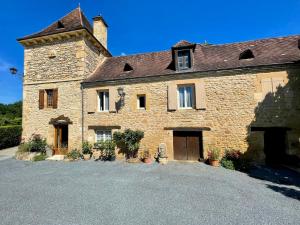 un gran edificio de piedra con una entrada delante de él en Chambre Périgourdine, en Beynac-et-Cazenac 10 fotos más