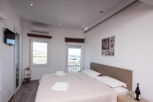 a bedroom with a bed with two towels on it at Olympia in Mýkonos City