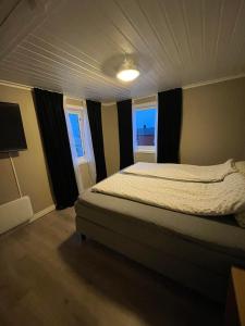 a bedroom with a bed and two windows at This Old House - Check in Breathe out in Strønstad +32 photos