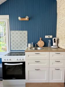 a kitchen with a stove and a sink at Studio Confort Bourg de Mer sur Gold Beach in Ver-sur-Mer