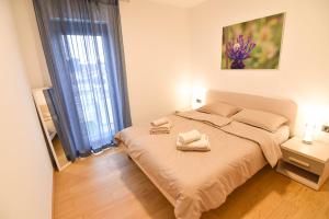 a bedroom with a bed with two towels on it at Luxury apartment Faro with sea view and swimming pool in Premantura +17 photos