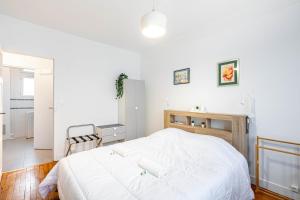 ein weißes Schlafzimmer mit einem großen weißen Bett. in der Unterkunft GuestReady - Contemporary comfort near Paris in Clichy