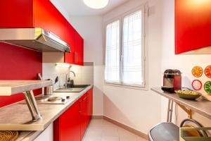 eine Küche mit roten Schränken und einem Fenster in der Unterkunft GuestReady - Contemporary comfort near Paris in Clichy