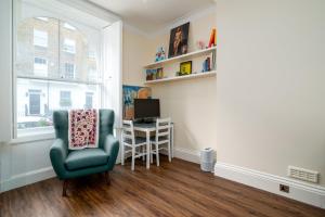 um quarto com uma cadeira, uma secretária e uma janela em GuestReady - Fantastic Apt near Regent's Park em Londres