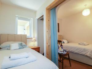 a bedroom with two beds and a window at Summerfield Cottage in Gorran Haven