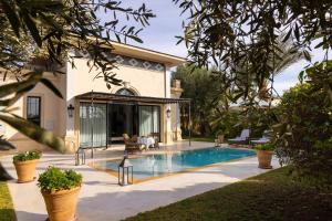 a swimming pool in front of a house at Palais Ronsard Relais & Chateaux in Marrakesh