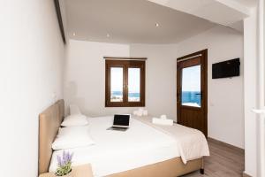 a bedroom with a bed with a laptop on it at Olympia in Mýkonos City