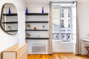 ein Ankleidezimmer mit schwarzen Regalen und einem Spiegel in der Unterkunft GuestReady - Modern stay near the Pantheon in Paris