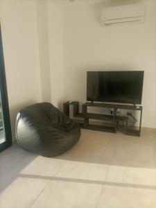 um pufe sentado no chão ao lado de uma televisão em Alka hermoso y cómodo departamento em Morón