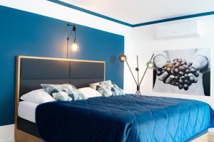 ein blaues Schlafzimmer mit einem Bett mit blauer Bettwäsche und Kissen in der Unterkunft KRACHER Ferienhaus Landhaus No 1 in Illmitz