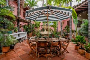 a table and chairs under an umbrella on a patio at Hotel Boutique Al Alma in Santa Fe de Antioquia