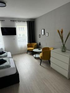 een slaapkamer met een bed en een tafel en stoelen bij Guben Wohnungen in Guben