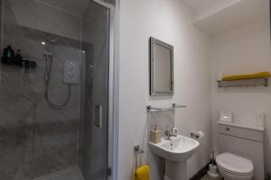 a bathroom with a shower and a sink and a toilet at Victoria Apartments in Skegness
