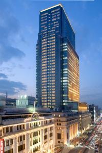a tall building with lights on in a city at Mandarin Oriental, Tokyo in Tokyo