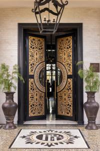 een lobby met een deur waar twee mensen naar binnen lopen bij Palais Ronsard Relais & Chateaux in Marrakesh
