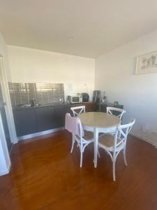 a table and chairs in a room with a kitchen at Self contained guest house - sleeps 4 in Gold Coast