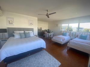a bedroom with a large bed and a living room at Self contained guest house - sleeps 4 in Gold Coast