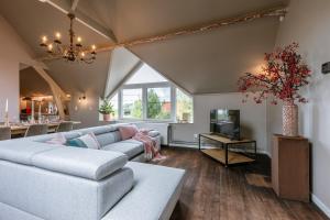 - un salon avec un canapé et une télévision dans l'établissement Charming apartment "De Watersnip" in De Haan, au Coq