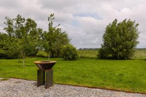 un planteur assis au-dessus d'un champ d'herbe dans l'établissement Charming apartment "De Watersnip" in De Haan, au Coq