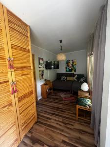 a living room with a couch and a large wooden door at Fiołek - domek nad Szelągiem Wielkim in Ostróda