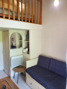 Habitación pequeña con cama y escritorio. en Agréable et paisible studio, en Franqueville-Saint-Pierre