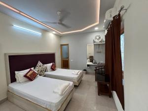 a hotel room with two beds and a bathroom at Max Guest House in Agra