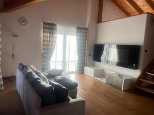 a living room with a couch and a flat screen tv at Casa Valsassina in Primaluna