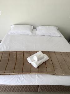 łóżko z dwoma ręcznikami na górze w obiekcie Pousada Lobo Guará w mieście São João Batista do Glória