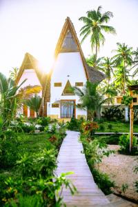 a house with a pathway in front of it at La Perla Beach Resort, Zanzibar - Your Beachfront Private Haven in Pwani Mchangani