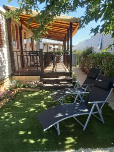 a backyard with two lounge chairs and a gazebo at Fabuleux mobil-homme 4/6 personnes in Fréjus