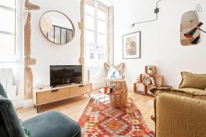 - un salon avec une télévision et un canapé dans l'établissement GuestReady - Bohemian and Chic Studio Vieux Lyon, à Lyon