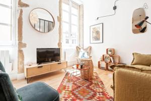 リヨンにあるGuestReady - Bohemian and Chic Studio Vieux Lyonのリビングルーム(テレビ、ソファ付)