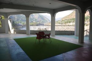 two chairs sitting on a green rug on a balcony at Besham Inn, Besham in Besham