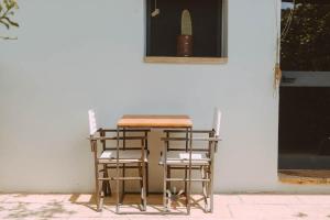 un tavolo e due sgabelli seduti accanto a un muro di Agriturismo tenuta Margherita a Torre Lapillo