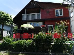 格奥尔盖尼Cabana Silvia的一间有红色椅子和一把雨伞的房子