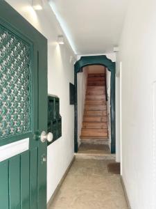 un couloir avec une porte verte et un escalier dans l'établissement GuestReady - Luxury with Private Terrace in Lapa, à Lisbonne
