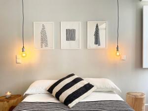 - une chambre dotée d'un lit avec 3 photos sur le mur dans l'établissement GuestReady - Luxury with Private Terrace in Lapa, à Lisbonne