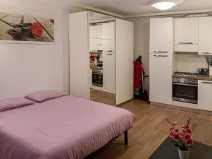 1 dormitorio con 1 cama grande y cocina en La Piccola Corte, en Trieste