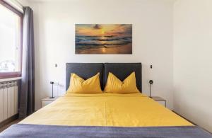 a bedroom with a large bed with yellow sheets at Bernardi apartment il Lauro in Lazise +26 photos